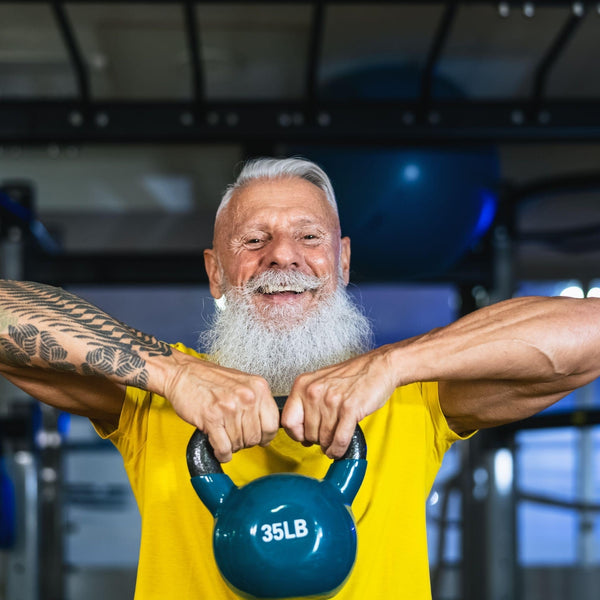 Man lifting a blue 35-pound kettlebell in a gym setting